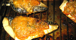 鯖の鯖を焼く。７〜8分どおり火を通してから、味噌を皮面にまんべんなく塗り、焼き色が付くまで（5〜6分）焼いて仕上げる。