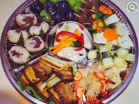 エビの天ぷら、焼き豚、エビチリ、ピクルス、デザート、フルーツなどの盛り合わせ